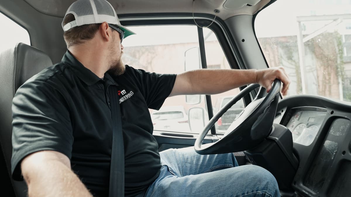 A CPM Sweeping driver at the wheel of a sweeper truck